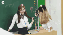 two girls are standing in front of a blackboard with the word to on it
