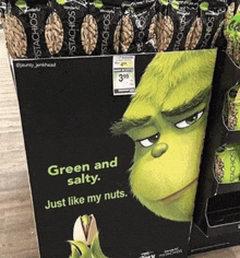 a display of pistachios with a picture of the grinch saying green and salty just like my nuts