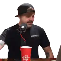a man sitting at a table with a red big foot java mug