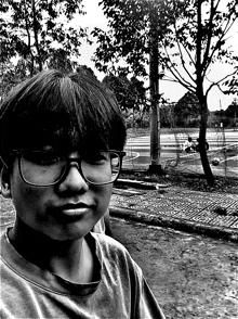a young boy wearing glasses looks at the camera