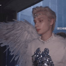 a close up of a person wearing angel wings and a white shirt