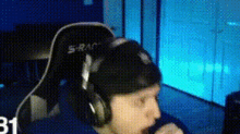 a person wearing headphones is sitting in a chair with the number 31 on the bottom right corner .