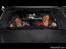 a man and a woman are driving a car and laughing