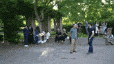 a group of people are gathered in a park with an exit sign in the foreground