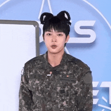 a man in a military uniform has a cat ear headband on his head .