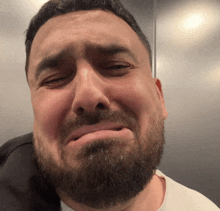 a man with a beard making a sad face