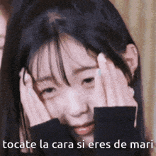 a girl is covering her face with her hands and the words " tocate la cara si eres de mari " are below her
