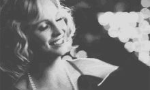 a black and white photo of a smiling woman