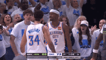two oklahoma city thunder players are standing in front of a crowd