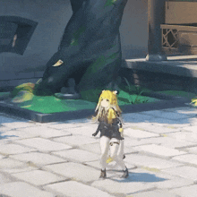 a girl with blonde hair is walking on a brick sidewalk in front of a tree