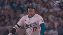 a dodgers baseball player wearing number 17 runs towards home plate