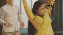 a woman in a yellow dress is dancing in front of a man who says signal