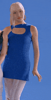 a woman in a blue dress is standing in front of a blue wall .