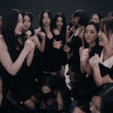 a group of young women wearing black dresses are posing for a picture