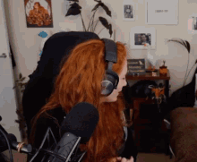a woman with red hair is sitting in front of a microphone .