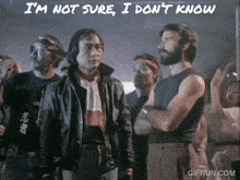 a group of men are standing in front of a sign that says i 'm not sure i dont know