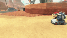 bowser is driving a toy car on a desert track