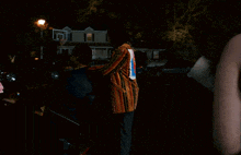 a person standing in front of a house with a car parked behind them