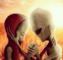 two aliens are standing next to each other in a field holding hands .