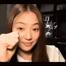 a close up of a woman 's face with a fist in front of her face .