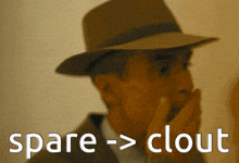 a man wearing a hat is covering his mouth with his hand and the words spare > clout are visible behind him