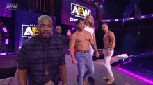 a group of men are standing in front of a aew sign