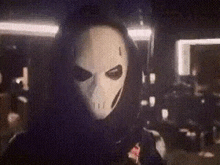 a person wearing a white mask with a hood on their head .
