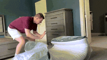 a man is wrapping a mattress in plastic