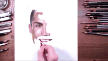 a drawing of a man 's face with prismacolor pencils on the table