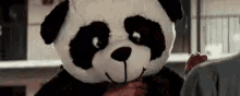 a person wearing a panda bear costume is holding a bloody hand .