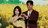 a man and woman are making a heart shape with their hands