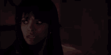 a close up of a woman 's face in the dark with a blurred background .