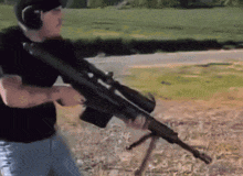 a man wearing headphones is holding a sniper rifle