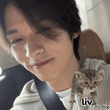 a man is sitting in a car with a picture of a cat behind him that says liv on the bottom