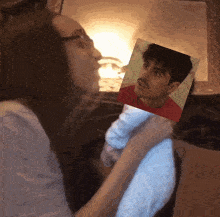 a woman holds a picture of a man in a red shirt