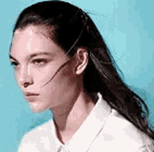 a close up of a woman 's face wearing a white shirt .