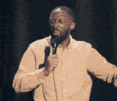 a man with a beard is singing into a microphone on a stage