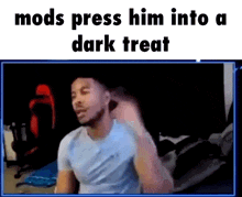 a man is sitting in front of a screen that says mods press him into a dark treat ..