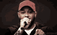 a man wearing a red hat is singing into a microphone with the words pybanki written below him