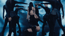 a woman in a black dress is surrounded by other women