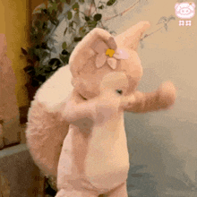 a stuffed animal with a flower in its ear is standing on its hind legs .
