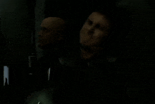a man is pointing a gun at another man with a yellow skull on his face