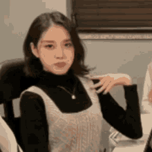 a woman is sitting in a chair and looking at the camera .