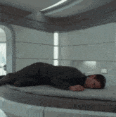 a man laying on his stomach on a bed in a room