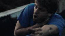 a man in a blue shirt is being choked by another man in a blue shirt .