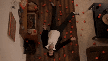a man in a suit is upside down on the floor