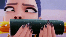 a woman with long nails is holding a roll of sushi in her hands .