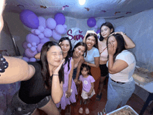 a group of women posing for a picture in front of a banner that says sam