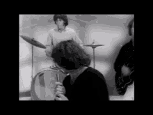 a black and white photo of a group of people playing instruments