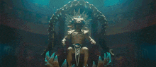 a statue of a man with a crown on his head sits on a throne